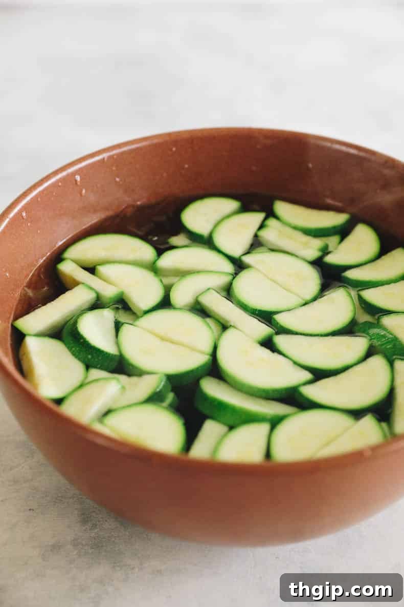 Maximize Your Zucchini Harvest: Freezing Made Easy 5 Blanched zucchini quickly transferred into a large bowl filled with ice water, halting the cooking process and preserving texture.