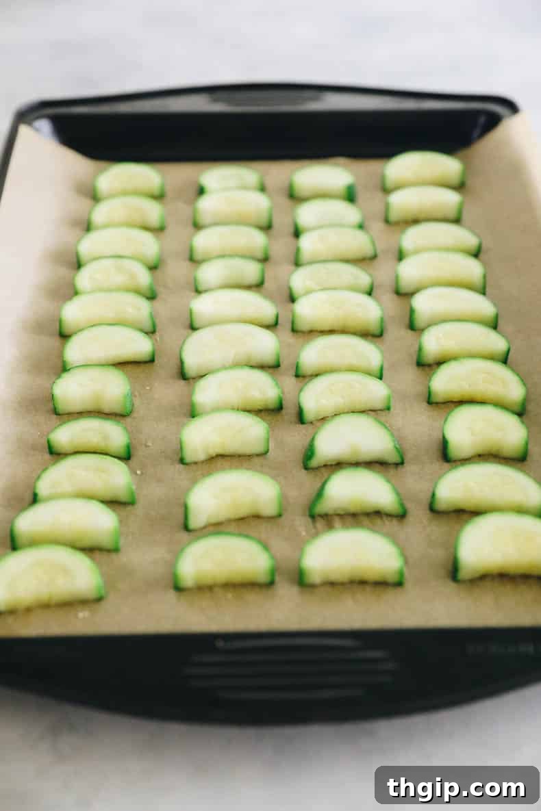 Maximize Your Zucchini Harvest: Freezing Made Easy 6 Individual pieces of blanched zucchini spread in a single layer on a parchment-lined baking sheet, flash freezing to prevent clumping.
