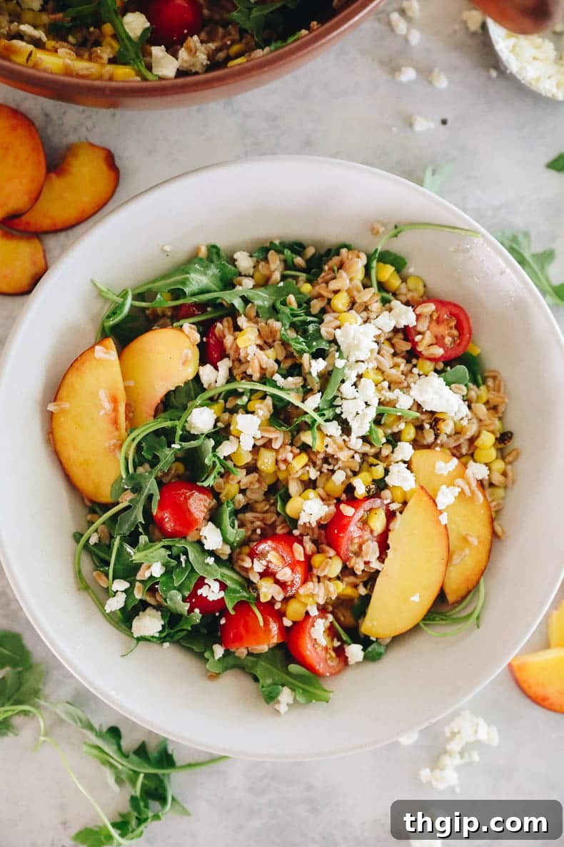 Vibrant Summer Farro Bowl 8 Another overhead shot of the delicious summer farro salad, showcasing the colorful mix of ingredients including peaches, corn, tomatoes, and arugula, all ready to be enjoyed.