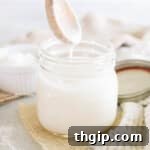 Homemade coconut butter in a mason jar with a wooden spoon, ready to be served.