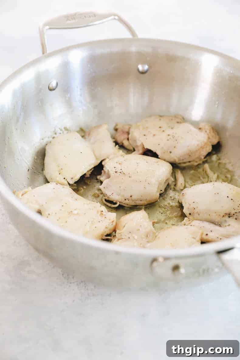 cooked chicken thighs in a pot, golden brown and ready to be set aside