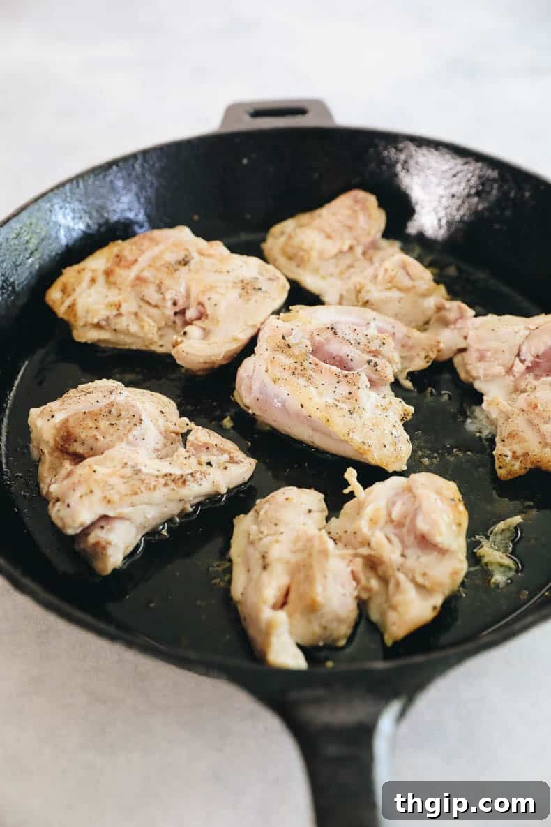 Zesty One-Pan Cilantro Lime Chicken and Rice 3 Perfectly browned chicken thighs resting in a cast iron pan before being set aside.