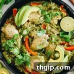 Zesty One-Pan Cilantro Lime Chicken and Rice 8 Close-up of a succulent chicken thigh, vibrant cilantro, fresh lime, and fluffy rice in a cast iron pot.