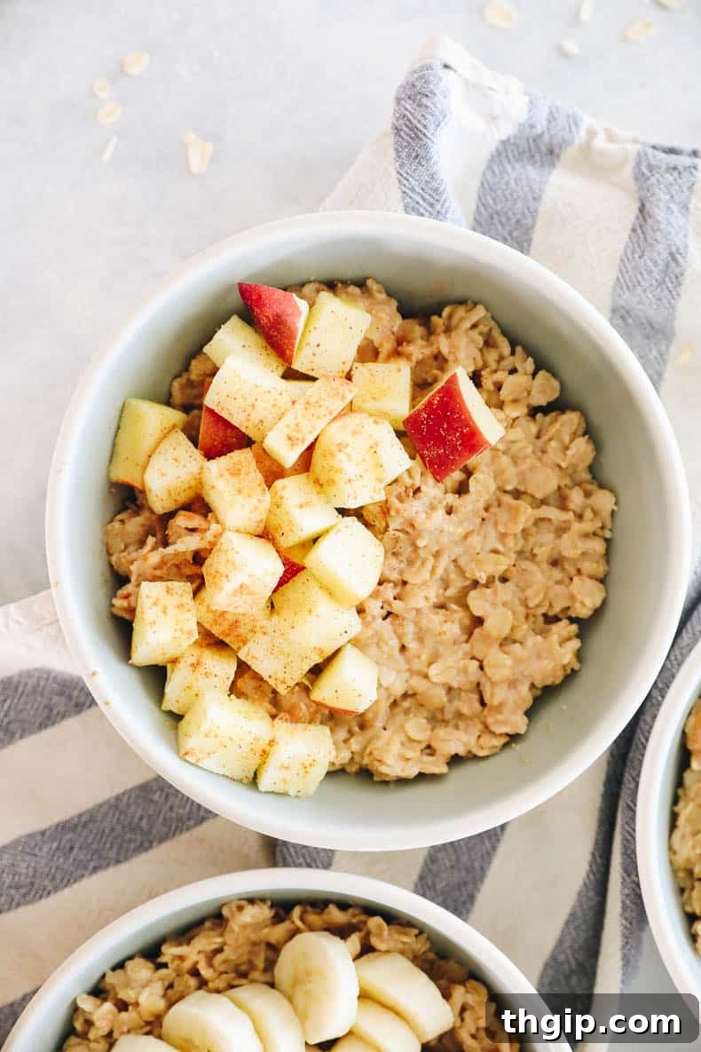 Mastering Your Morning Oats 11 A warm bowl of oatmeal elegantly topped with thinly sliced apples, dusted with a generous amount of cinnamon and a hint of nutmeg, perfect for a cozy morning.