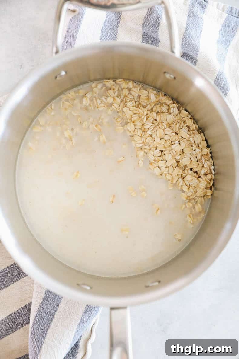 Mastering Your Morning Oats 4 Raw rolled oats being mixed with milk in a pot on a stovetop, ready for cooking.
