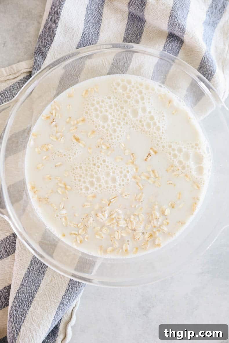 Mastering Your Morning Oats 6 Rolled oats soaking in milk within a transparent glass bowl, prepared for microwave cooking.