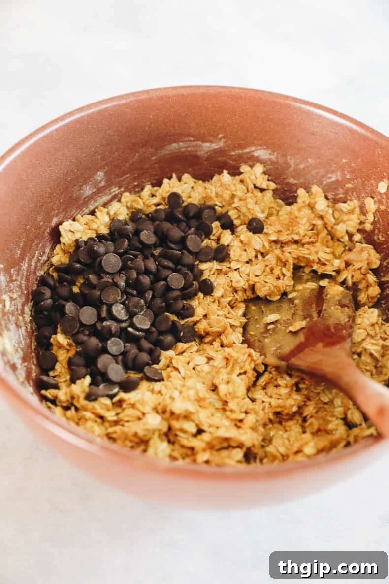 Power-Packed Protein Granola Bars 4 All granola bar ingredients combined in a large brown mixing bowl, ready for chocolate chips.