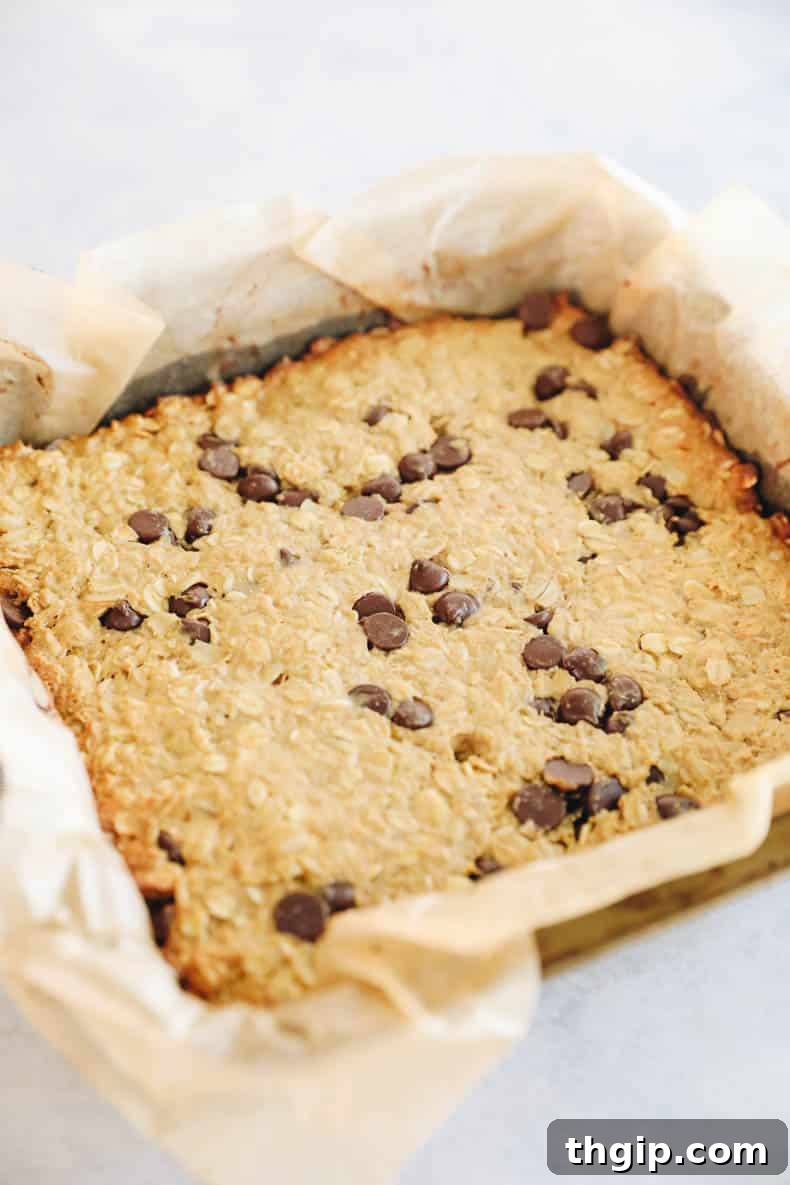 Power-Packed Protein Granola Bars 5 Freshly baked protein granola bars cooling in a parchment paper lined baking pan.