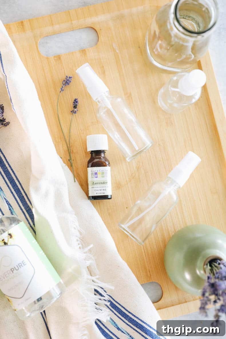 DIY Lavender Bliss Spray 3 Closeup of a clear glass spray bottle containing lavender mist and dried lavender sprigs.