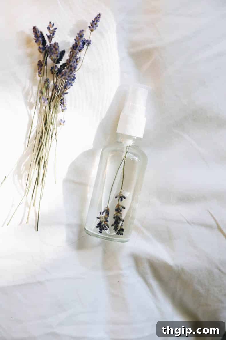DIY Lavender Bliss Spray 9 A serene image of a glass spray bottle filled with lavender pillow spray, surrounded by fresh lavender sprigs.
