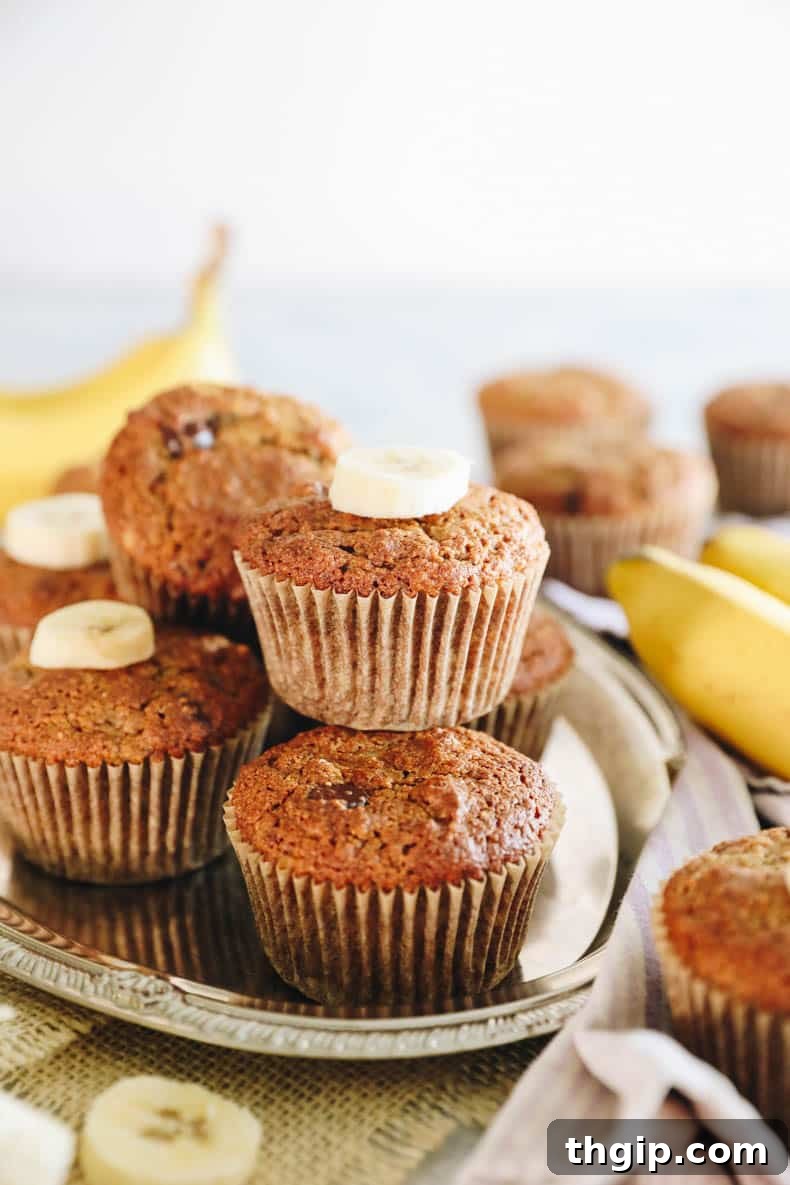 Stacked almond flour banana muffins on a silver platter, highlighting their golden-brown tops and moist texture.