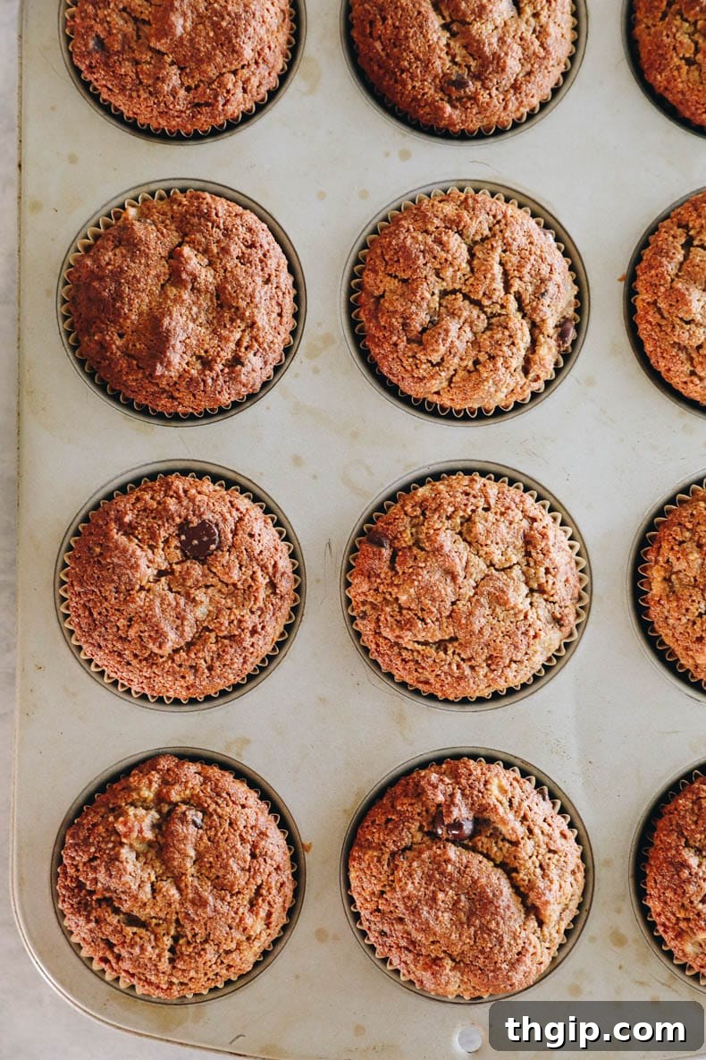 Close-up image of almond flour banana muffins baking in a muffin pan, showing their rising tops.