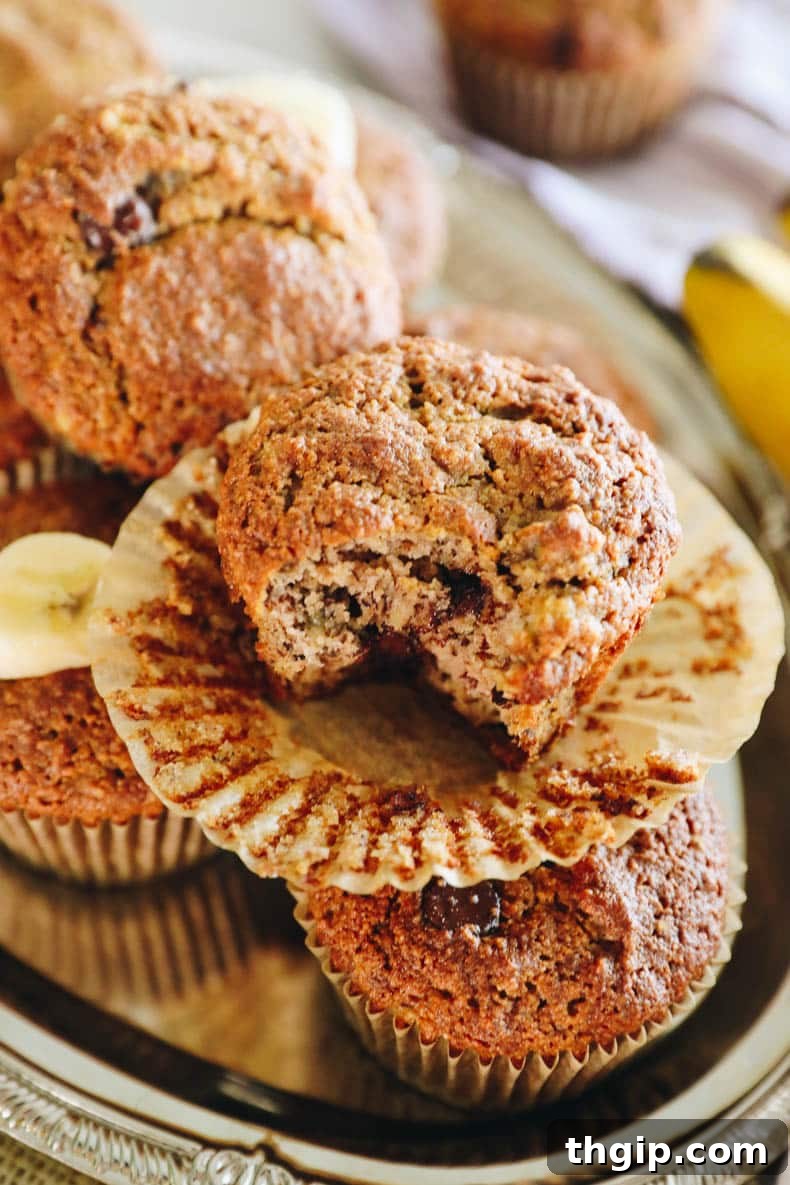 A single almond flour banana muffin with a bite taken out, showing its moist interior and chocolate chips.
