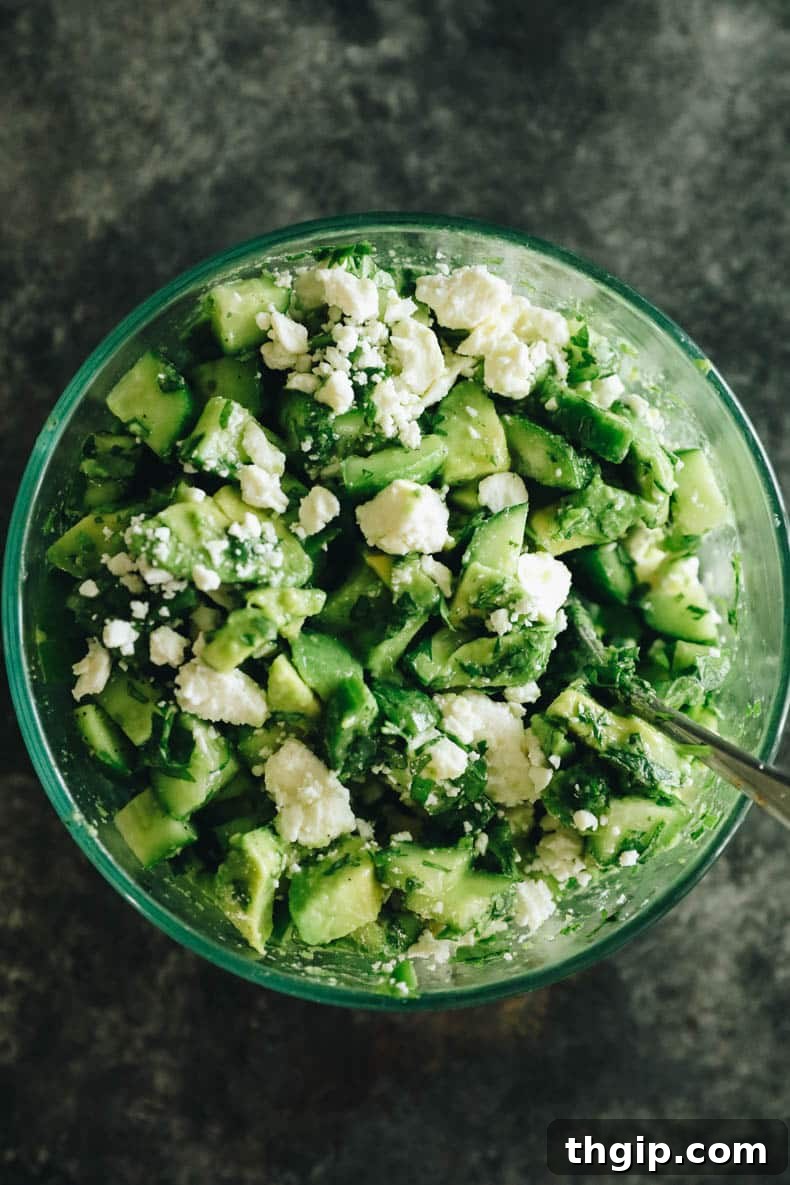 avocado salsa in a glass bowl with feta and cucumbers