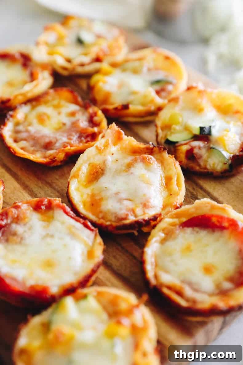 Mini tortilla pizza cups arranged neatly on a wooden cutting board, showcasing golden-brown tortillas, melted cheese, and various toppings, ready to be served as a quick meal or appetizer.