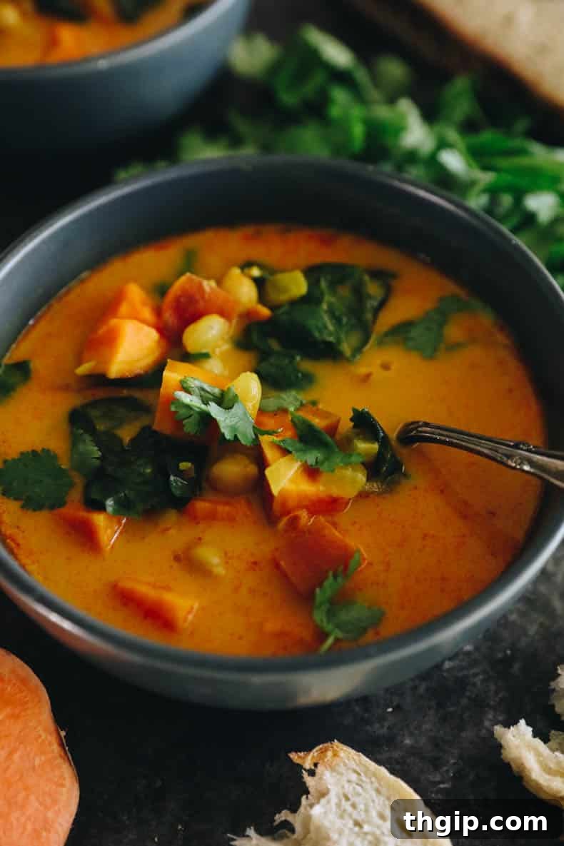 A vibrant and comforting bowl of curried sweet potato soup, garnished with fresh herbs, ideal for a wholesome meal.