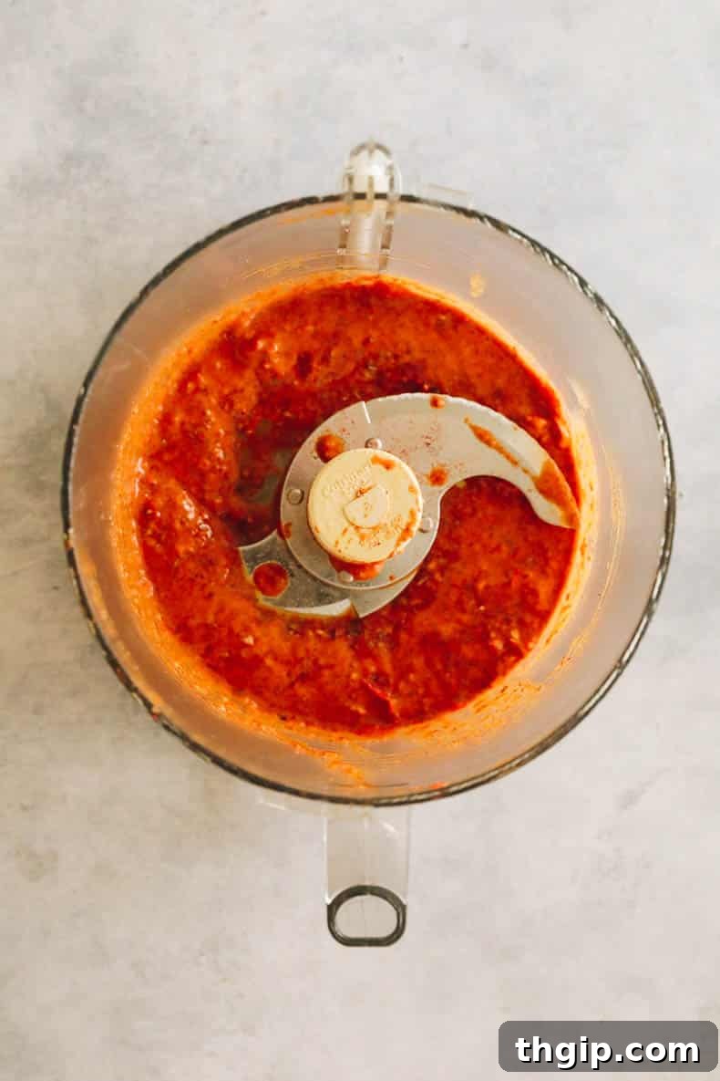 Peri peri sauce being blended in a food processor, vibrant red color.