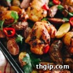 Peri peri chicken thighs on a sheet pan with roasted potatoes, fresh parsley and bird's eye chilis