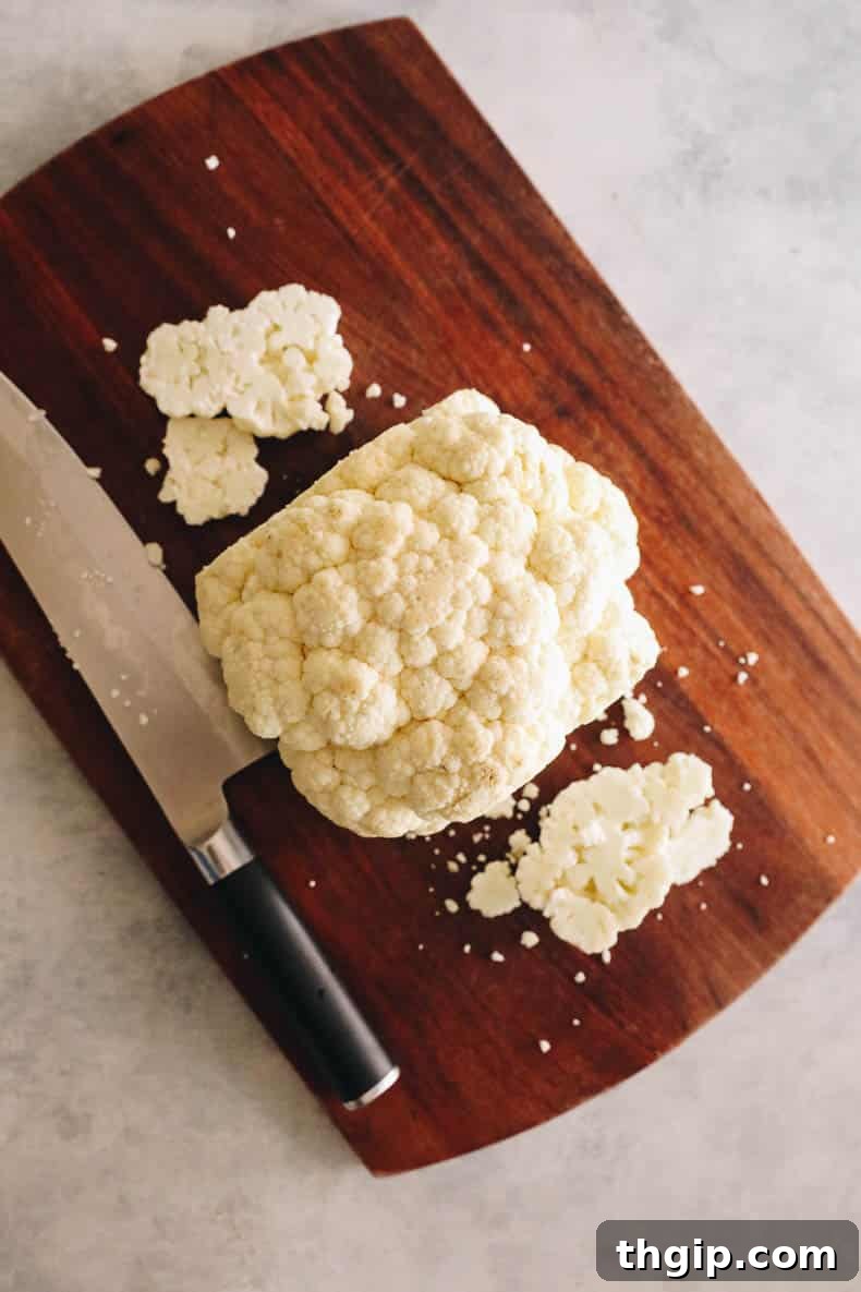 Golden Roasted Cauliflower Steaks 3 Cauliflower expertly cut into thick, uniform slices, resembling steaks, on a cutting board.