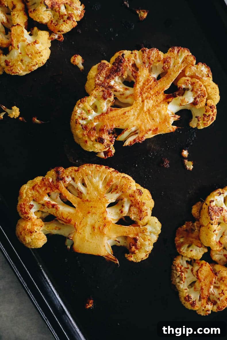 Golden Roasted Cauliflower Steaks 6 Marinated cauliflower steaks arranged neatly on a baking sheet, ready for oven roasting.