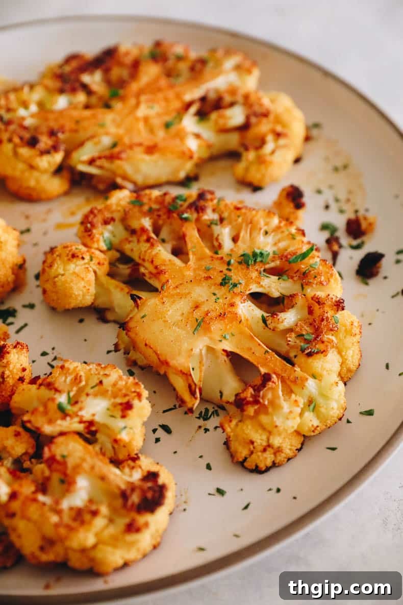 Golden Roasted Cauliflower Steaks 7 A beautifully plated cauliflower steak on a white plate, showcasing its golden-brown exterior and tender texture.