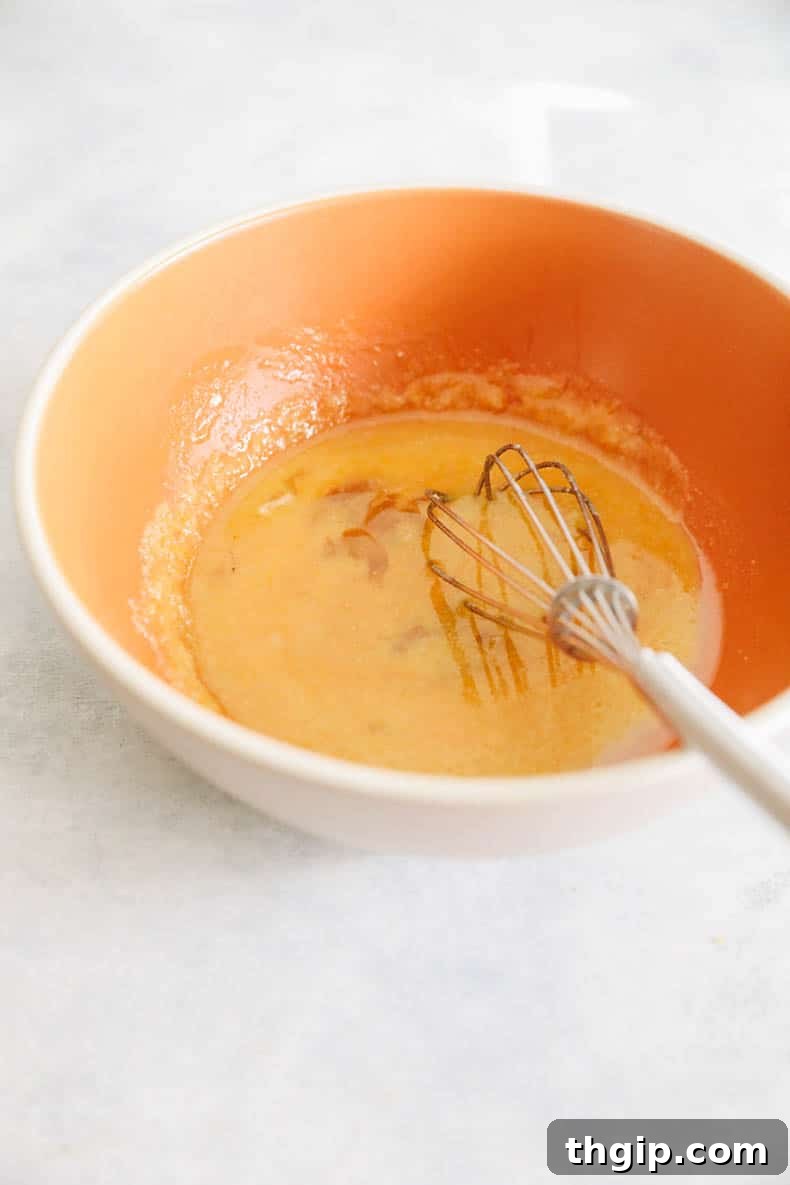 Guilt-Free Protein-Packed Brownies 3 wet batter for protein brownies in an orange bowl, ready for dry ingredients.