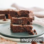 3 protein brownies stacked on top of each other on a plate plate.