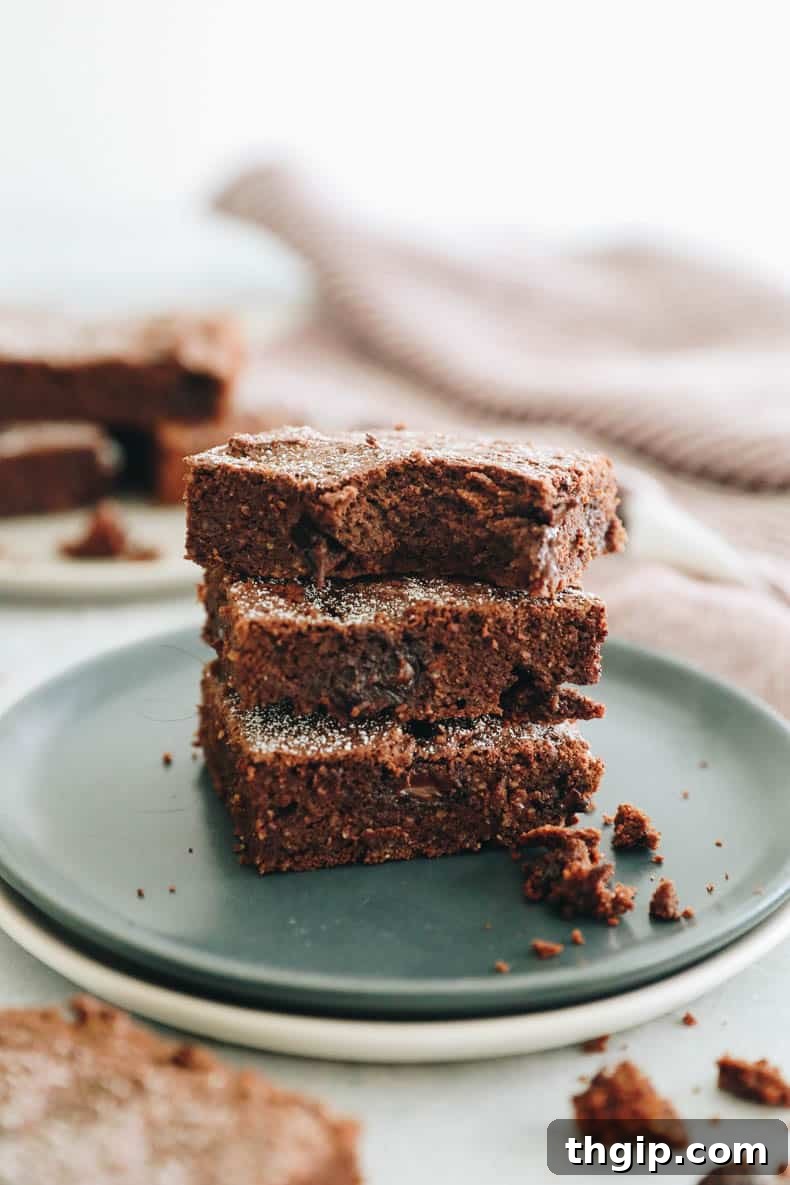 Guilt-Free Protein-Packed Brownies 8 protein brownies served on a wooden board, with one brownie broken to show fudgy inside.