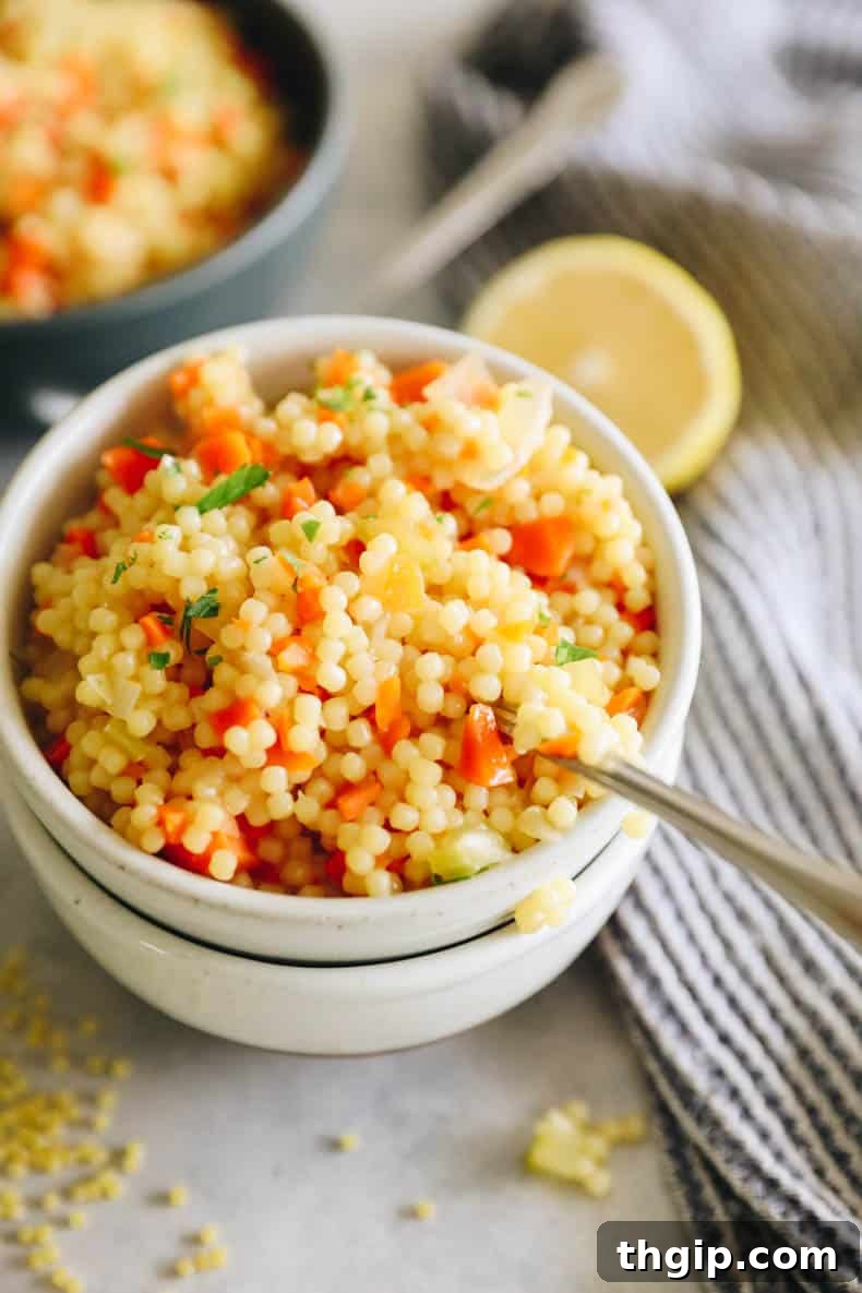 A serving of pastina soup in a white bowl, ready to be enjoyed.