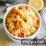 Thick, easy, and delicious pastina soup in a white bowl topped with lemon and parmesan.