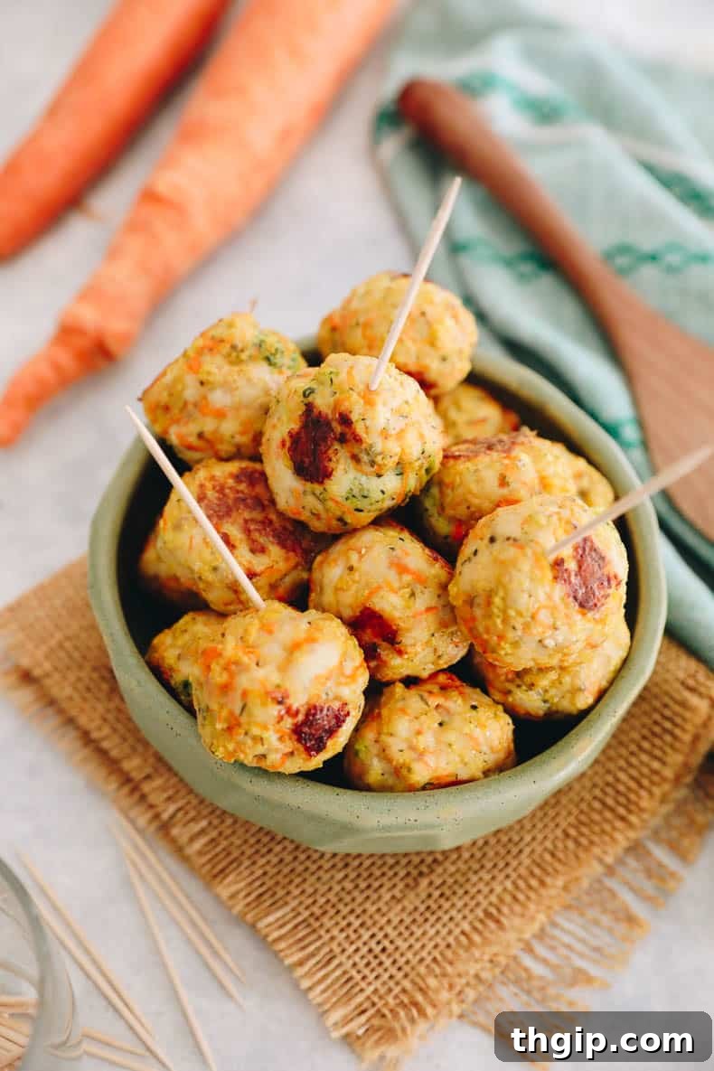 Kid-Approved Baked Chicken Meatballs with Secret Veggies 2 Baked chicken meatballs in a vibrant green bowl, garnished with fresh herbs, ready to be served.