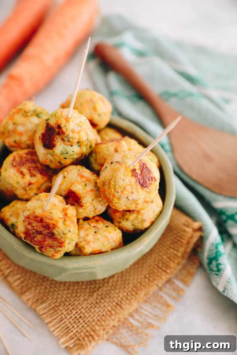 Kid-Approved Baked Chicken Meatballs with Secret Veggies 5 A baking sheet filled with freshly baked, golden-brown chicken meatballs, hot from the oven.