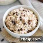 A small bowl of cottage cheese cookie dough overnight oats with scattered chocolate chips, ready to be enjoyed as a healthy breakfast.