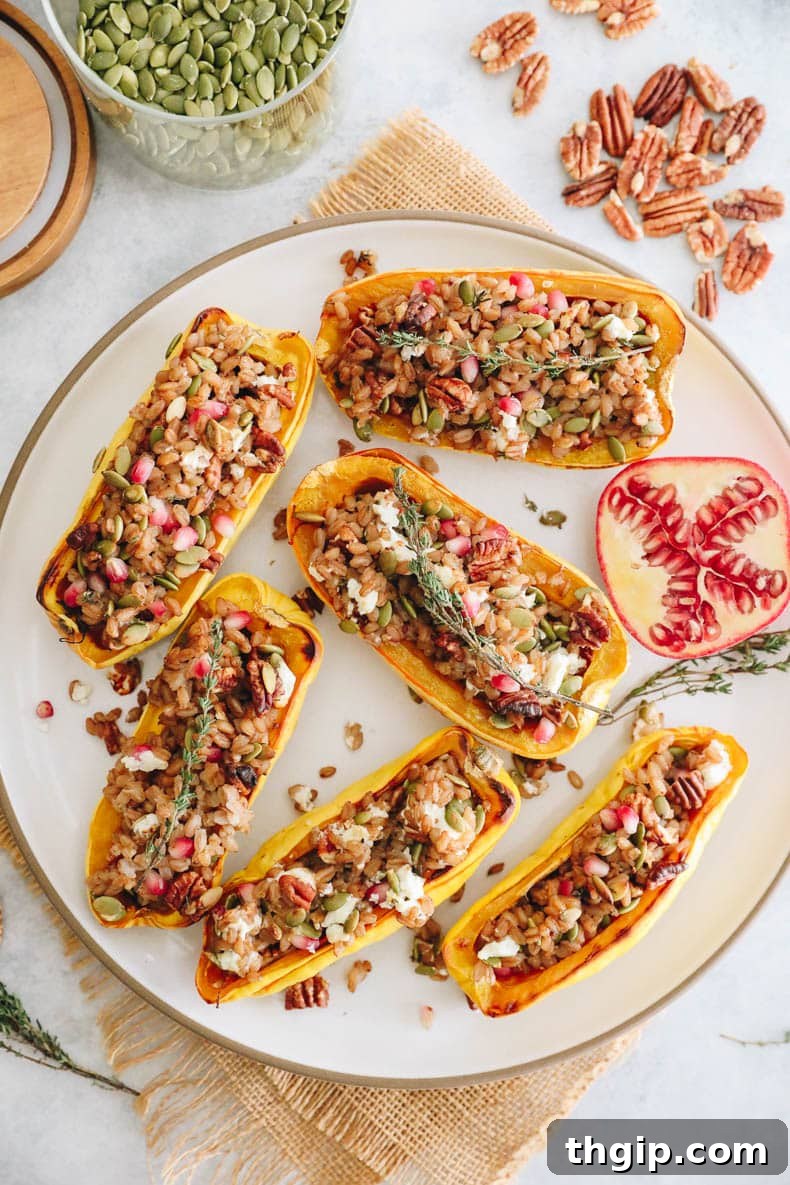 Hearty Farro-Filled Delicata Squash 9 A top-down view of two halves of stuffed delicata squash, garnished with fresh thyme and ready to eat on a rustic wooden surface.