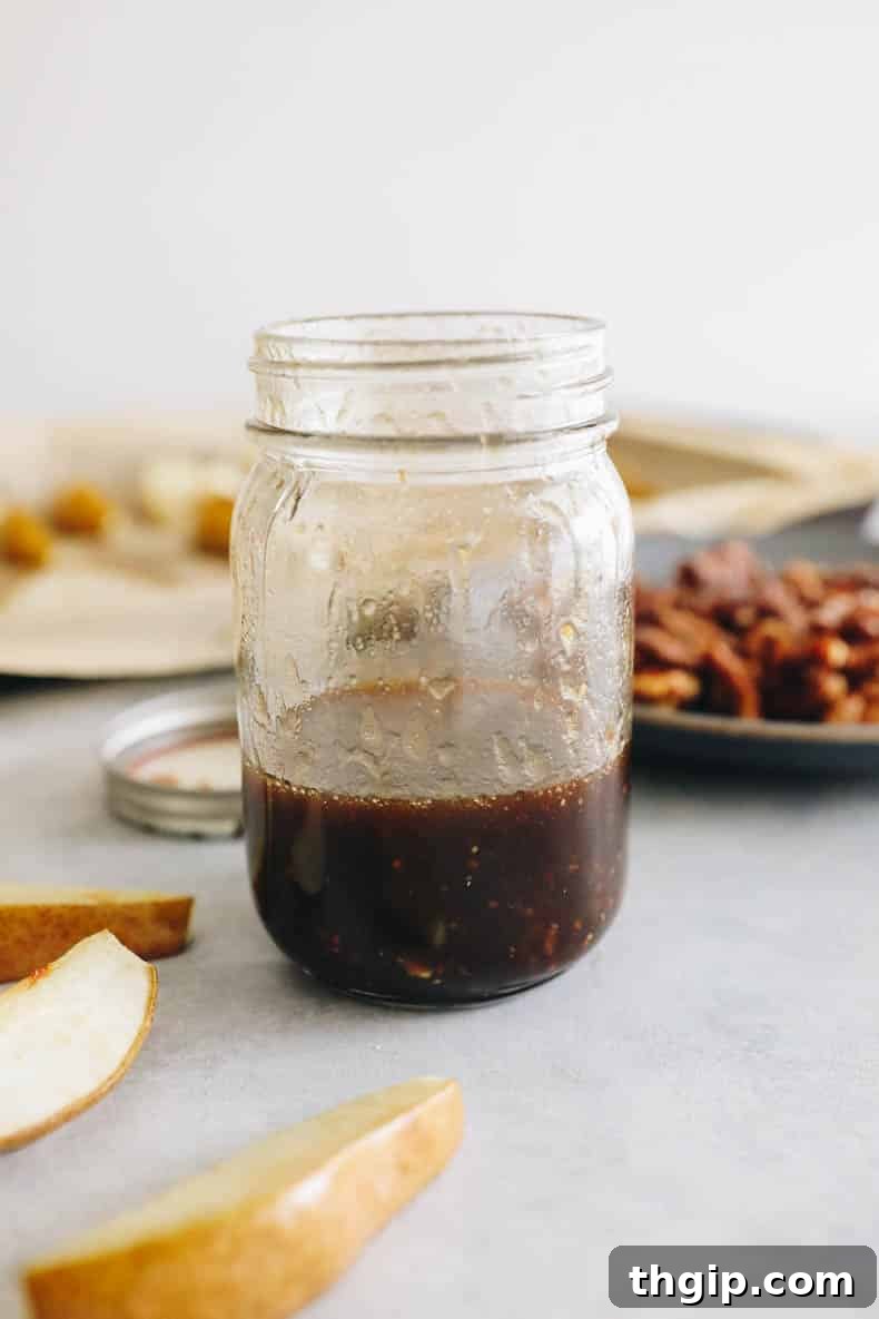 Caramelized Pear and Arugula Salad with Candied Walnuts 5 A mason jar filled with freshly prepared homemade balsamic vinaigrette dressing, ready to be shaken and served over the salad.