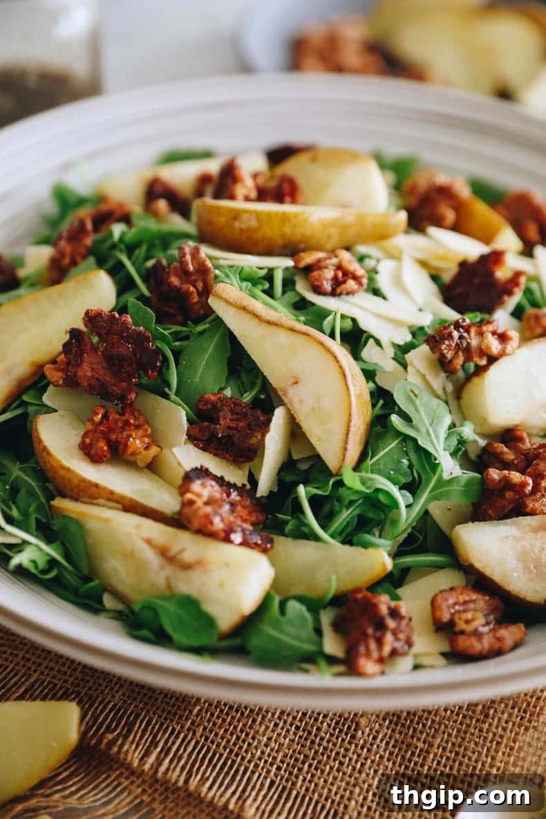 Caramelized Pear and Arugula Salad with Candied Walnuts 7 A close-up shot of the roasted pear salad, highlighting the crisp arugula, delicate shaved parmesan, and the appealing texture of candied walnuts against the tender pear slices.