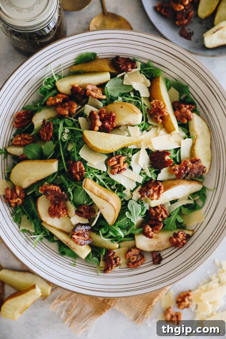 A final presentation of the roasted pear salad in a large white bowl, showcasing all its delightful components arranged artfully, ready for a gourmet meal.