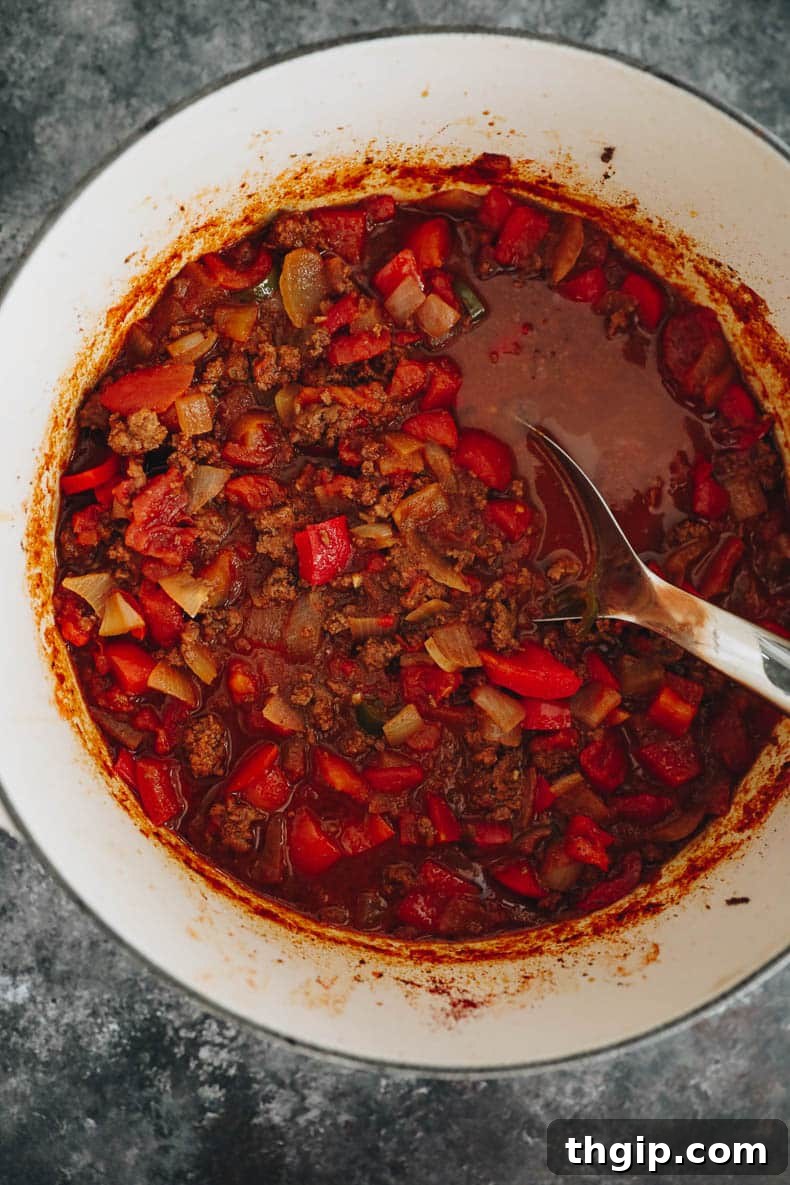 Texas-Style No-Bean Chili 5 A large pot filled with rich, simmering no-bean chili, bubbling gently as flavors combine.