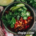 A delicious carnivore chili recipe with no beans in a green bowl, beautifully topped with fresh jalapeño, lime, and cilantro for garnish.