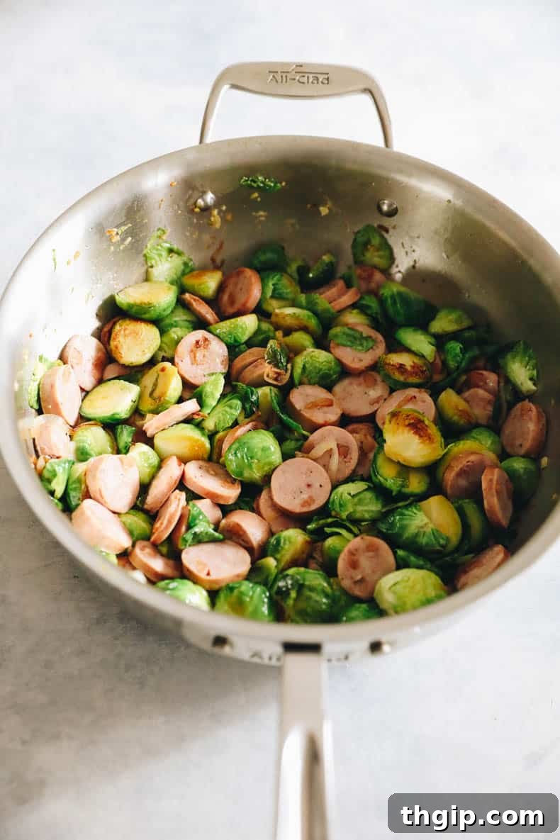 Hearty Chicken Sausage Pasta 4 Chicken sausage and brussels sprouts cooking together in a large pot, perfectly browned.