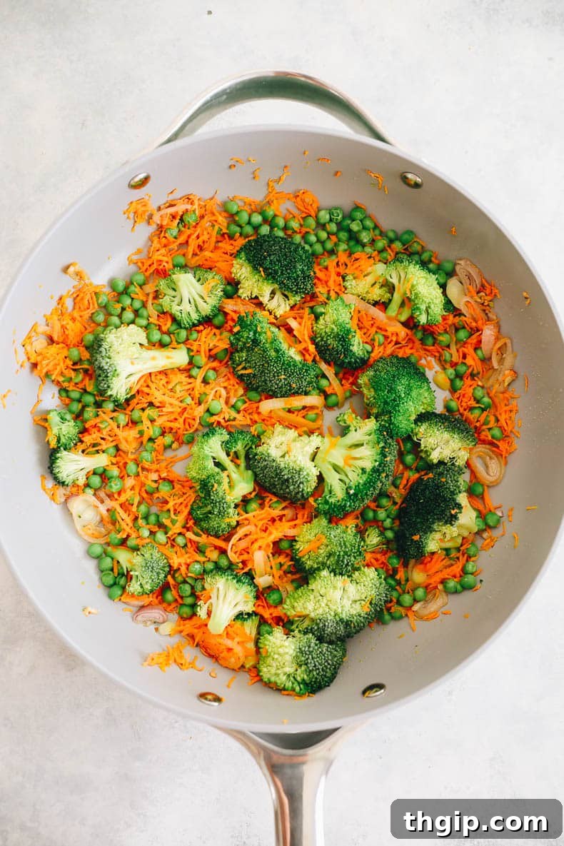 Fragrant Coconut Curry Rice with Vegetables 3 carrots, peas, broccoli, shallot and garlic cooked in a caraway pot.