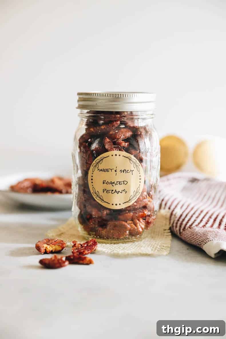 Candied Chili Pecans 2 Sweet and spicy roasted pecans beautifully presented in a clear mason jar, adorned with a charming brown canning label, ready for gifting or enjoying.
