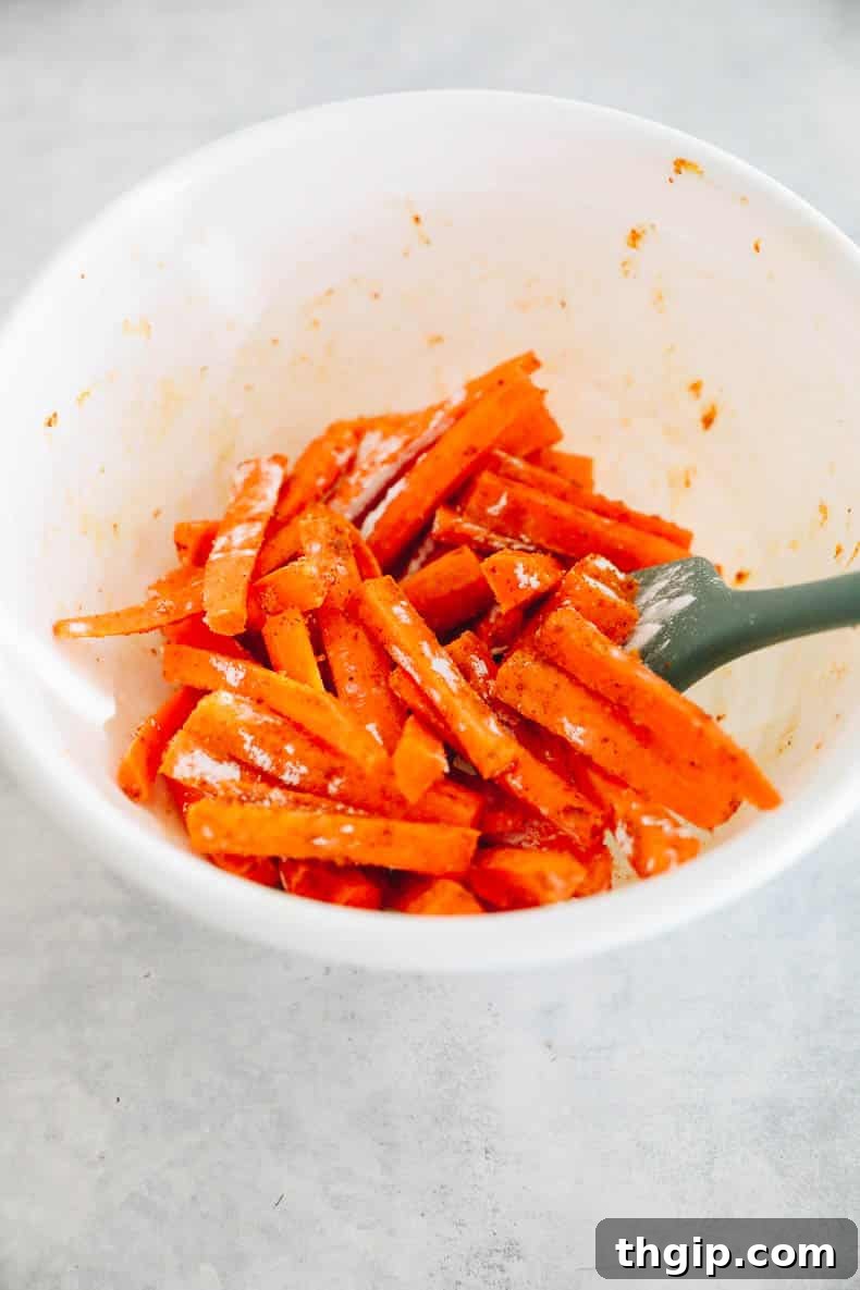 Golden Oven-Baked Carrot Sticks 4 Carrot fries in a bowl, generously coated with cornstarch and a blend of savory spices.