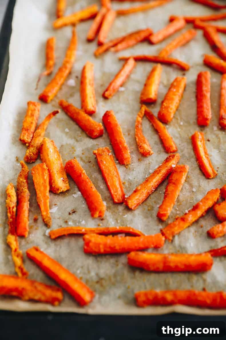 Golden Oven-Baked Carrot Sticks 5 crispy baked carrot fries spread out evenly on a baking sheet, golden and ready.