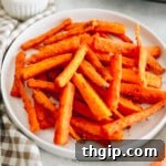 Crispy baked carrot fries on a white plate, close up.