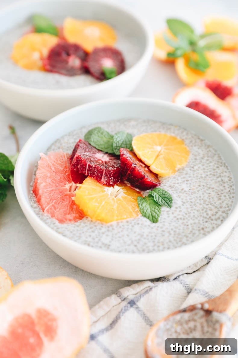 Sunshine Citrus Chia Pudding 5 Close up image of chia pudding in a blue and white bowl with grapefruit, blood orange and tangelo slices, garnished with fresh mint leaves for a vibrant, healthy aesthetic.