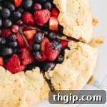 Mixed berry galette with an almond flour pie crust, served on a white plate.