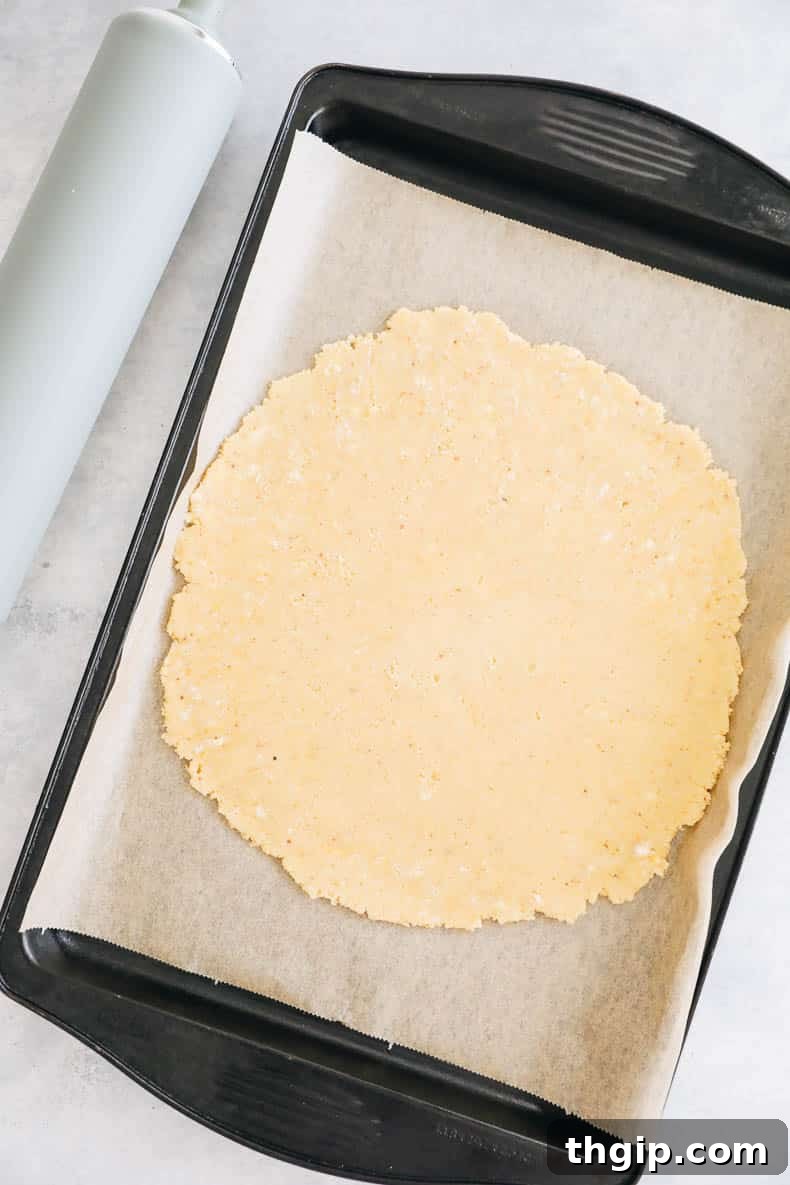 Berry Galette with Almond Flour Crust 5 Rolled out almond flour pie crust on parchment paper, placed on a baking sheet, ready for the filling.