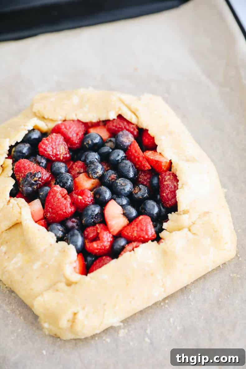 Berry Galette with Almond Flour Crust 9 The unbaked almond flour berry galette on a baking sheet, ready for the oven.