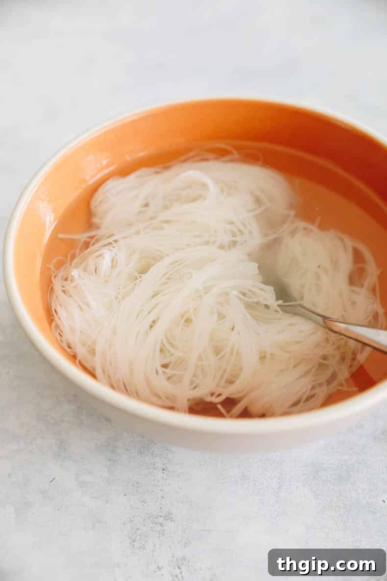 Creamy Spicy Crab Crunch 3 Freshly cooked rice noodles, translucent and ready to be added to the Kani Salad, resting in a colander.